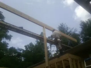 Carpenter setting a ridge beam over a new addition frame — Ice Dam Removal by Roofing Brothers in Nuevo