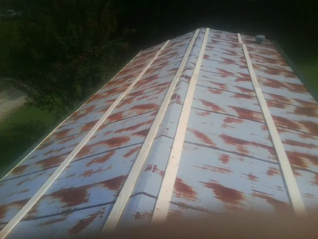 Rusted metal roof panels with new wood purlins before replacement — Storm Damage Roof Repair in Nuevo by Roofing Brothers