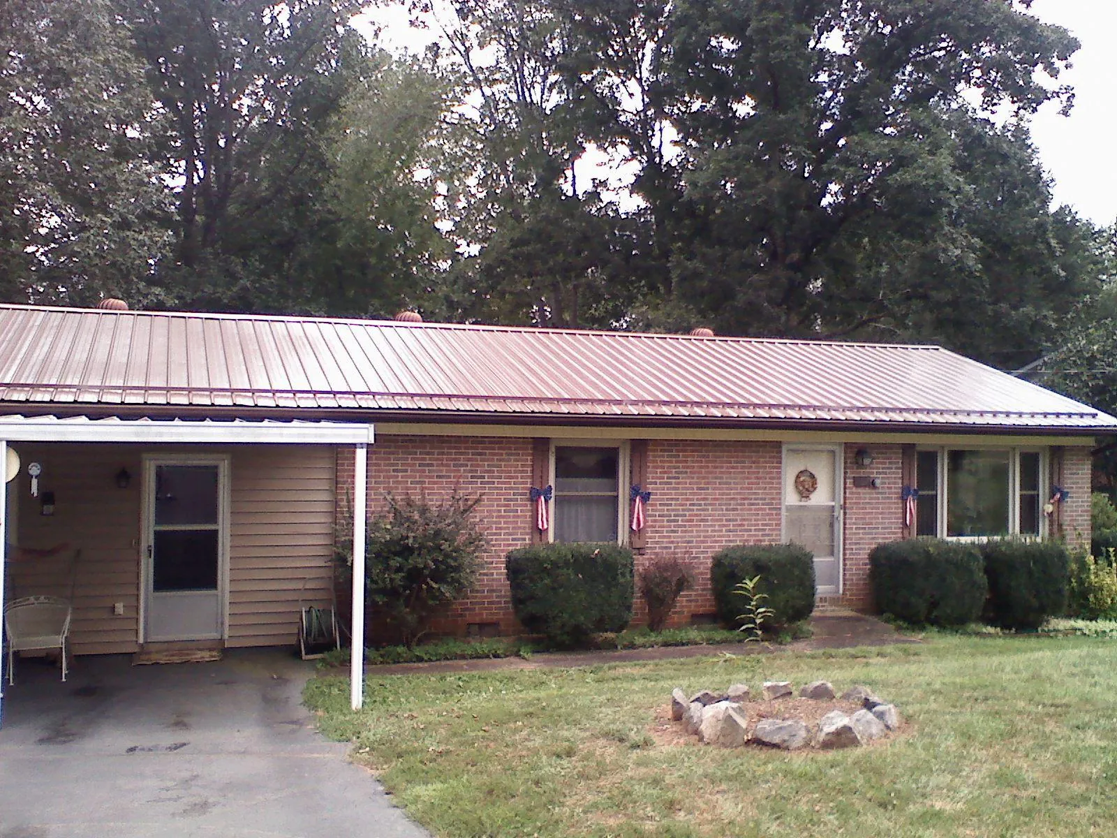 Bronze metal roof and carport on a brick ranch home — Roof Repair work by our crew in Nuevo